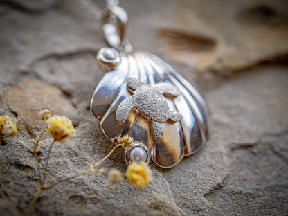 Sterling silver turtle resting on a seashell with two freshwater cultured pearls