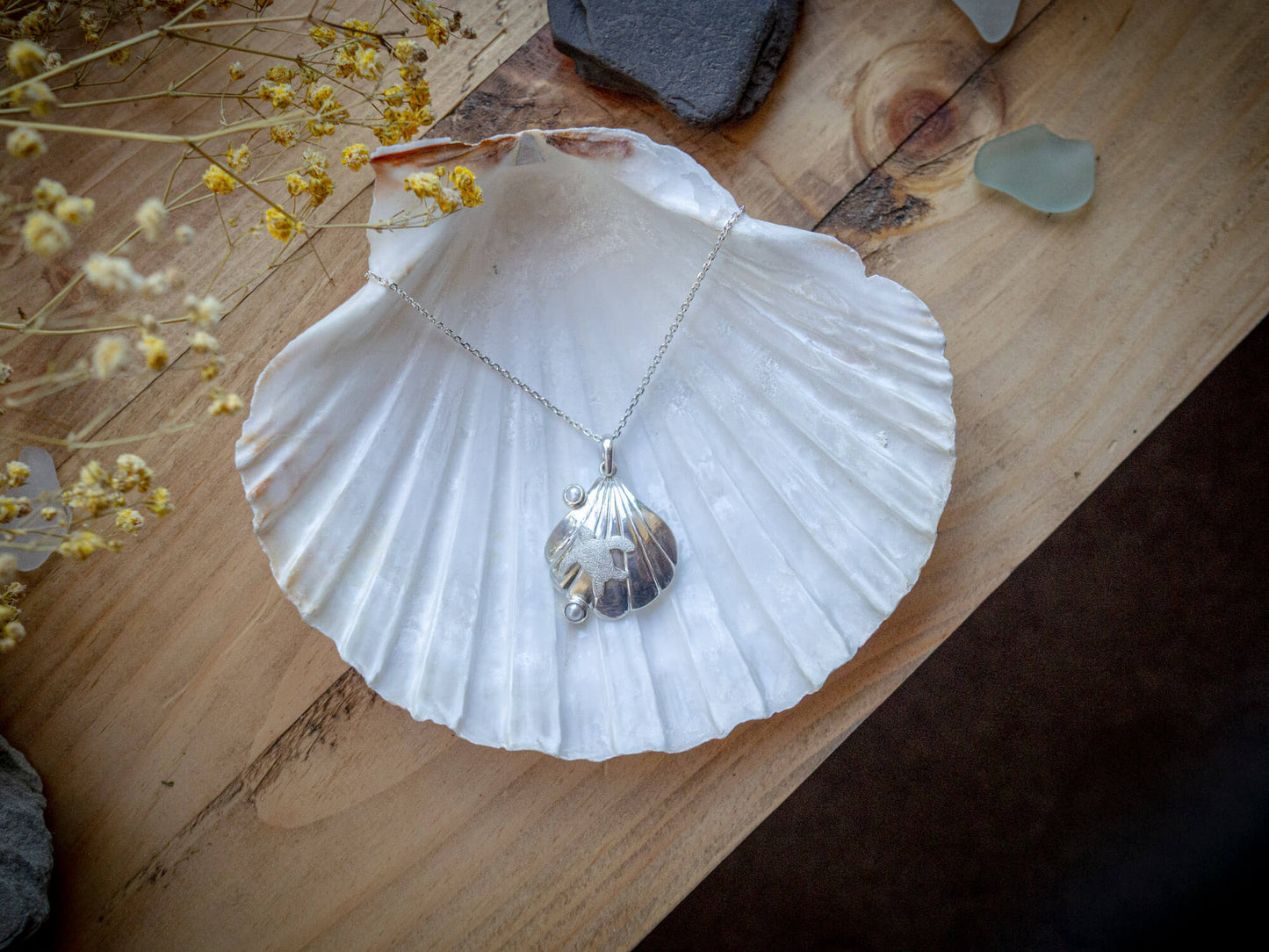 Sterling silver turtle resting on a seashell with two freshwater cultured pearls